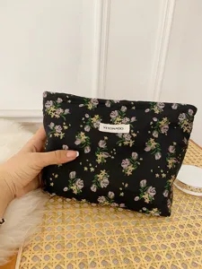 Floral makeup bag detail, black fabric with colorful floral pattern, portable storage pouch.