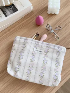 Detail shot of the floral makeup pouch with Yetonado label, showcasing vintage jacquard fabric.