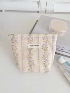Detail view of the floral cosmetic bag, featuring elegant vintage jacquard fabric and brand label.