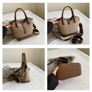 Detailed view of brown vintage bucket bag, monogram pattern, sturdy handles and cross body strap.