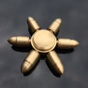 Close-up detail of a solid brass bullet shaped fidget spinner toy, smooth metallic mechanical spin.