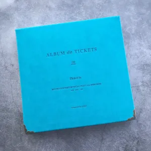 Close up view of the bright blue ticket collection album cover with vintage metal corner guards.