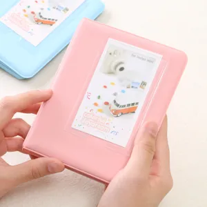 Pink instax mini photo album detail view showing 64 pockets and cute card insert slot.