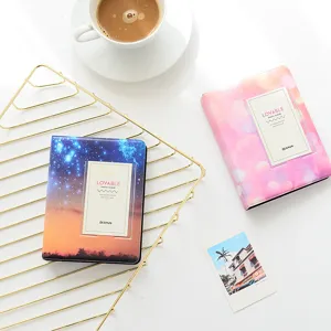 Close-up detail of mini polaroid photo album featuring starry and pink bokeh designs for collection.