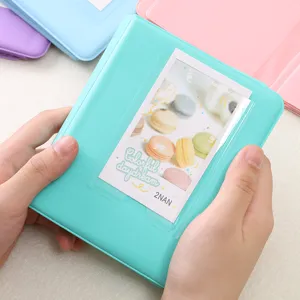 Close up detail of pastel mini photo album pocket holding card, clean display view.