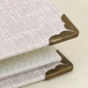 Mini 3 inch photo album detail closeup featuring fabric texture cover and vintage metal corner.