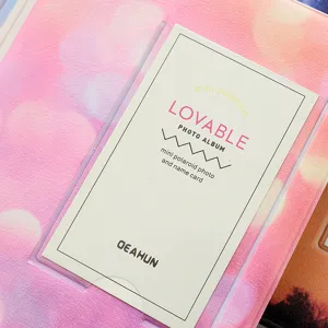 Mini photo album detail shot, pink gradient cover with clear pocket for 3-inch polaroid.