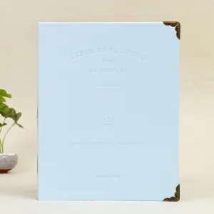 Close-up of light blue leather photo album cover with embossed text and metal corners.