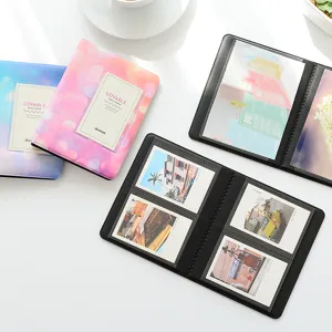 Mini 3-inch Polaroid photo album with colorful starry covers and clear inner pages for storage.