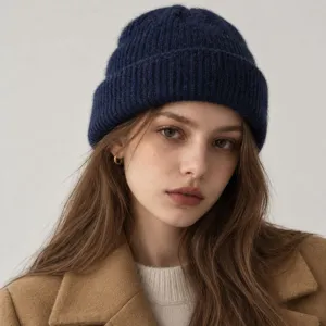 Close-up detail of the dark blue wool blend knitted beanie worn by model, showing texture.