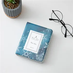 Primo piano del mini album fotografico blu con fiocchi di neve, dettaglio porta-photocard.