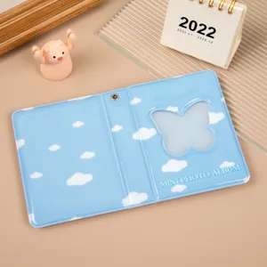 Vue détaillée d'un mini album photo bleu avec motif de nuages et fenêtre papillon pour photos.