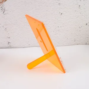 Vista detallada del marco de acrílico, soporte de tarjetas transparente naranja de mesa.