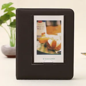 Dark brown mini photo album detail view, featuring clear front pocket for polaroid pictures.