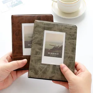 Close-up detail of vintage PU leather mini instant photo album, pockets for 3-inch film.