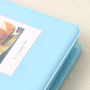 Close-up detail of light blue instax mini photo album cover pocket design texture.