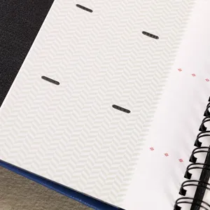 Detail view of 3-inch photo album inner page with green herringbone pattern and spiral binding.