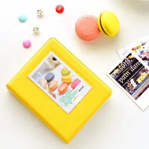 Detailed view of yellow mini photo album for 3-inch instax photos with cute macaron decor.