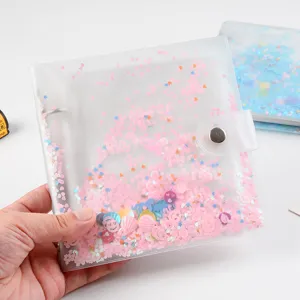 Close-up of clear glitter loose-leaf photo album binder with sparkly pink sequins inside.