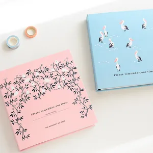 Vue détaillée d'albums photo pastel avec motifs d'oiseaux, parfaits pour souvenirs.