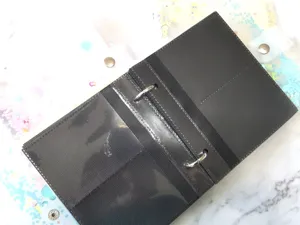 Loose leaf photo album detail showing black PP pockets and metal binder rings for card storage.