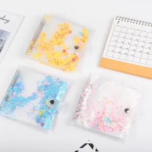 Transparent loose-leaf photo album detail with colorful glitter sequins and secure snap closure.