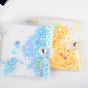 Close-up detail of transparent loose-leaf photo album with glitter sequins and snap button.