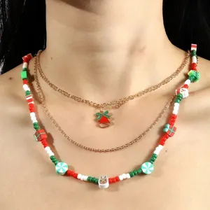 Collier multicouche de Noël avec pendentif cloche en émail et chaînes de perles festives.