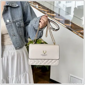 Detail shot of the quilted beige leather shoulder bag featuring exquisite gold chain straps.