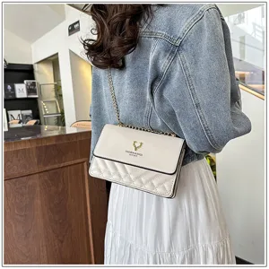 Quilted shoulder bag detail featuring elegant stitching, metallic chain strap and chic design.