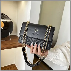 Detail view of stylish women black quilted chain shoulder bag with elegant deer logo design.