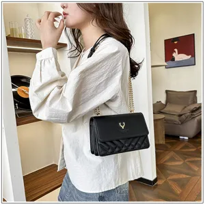Black quilted shoulder bag with gold chain strap and elegant deer emblem for daily fashion use.