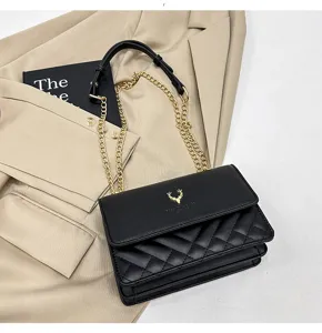 Detailed view of the black quilted shoulder bag with gold chain strap and chic deer hardware.