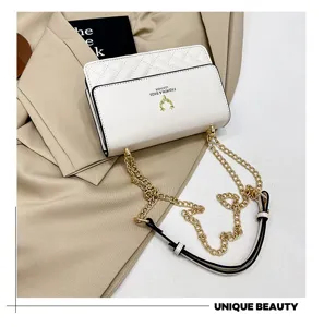Close-up detail of white quilted leather shoulder bag with chic gold chain strap and elegant design.