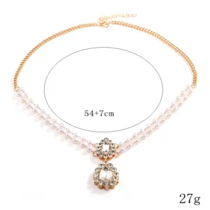 Detailed view of bohemian pearl rhinestone forehead chain, vintage gold hair accessory.