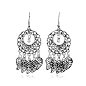 Detailed close-up of vintage silver boho dangle earrings with intricate filigree and leaf charms.