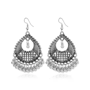 Detailed shot of vintage silver teardrop earrings with bead tassels and bohemian design.