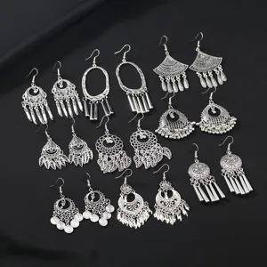 Close-up view of bohemian vintage silver-toned tassel earrings showing intricate metal textures.