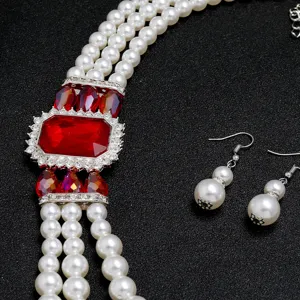 Gedetailleerde close-up van de bruidsparelketting set met prachtige rode edelsteen en strass.