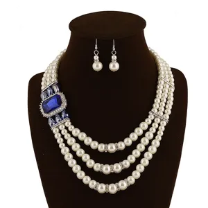 Gedetailleerd overzicht van meerlagige parelketting met blauwe kristallen edelsteen en oorbellen.