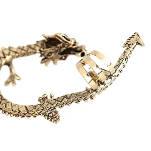 Primer plano del brazalete de oreja de dragón dorado antiguo, con estilo punk gótico y detalles.