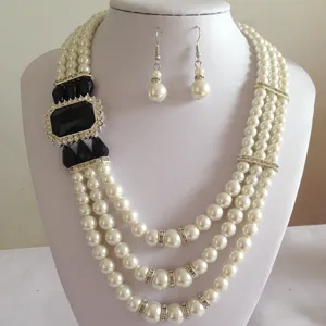 Gedetailleerd overzicht van de meerlagige kunstparelketting met zwarte edelsteen en oorbellen.