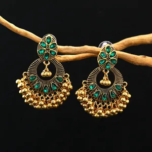Detail view of bohemian Indian ethnic style antique gold green crystal beaded tassel earrings.