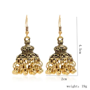 Détail boucles d'oreilles jhumka ethniques dorées vintage, pampilles en alliage ciselé.