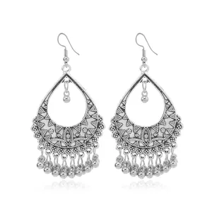 Detailed close-up of vintage silver boho teardrop earrings with delicate cutouts and beads.