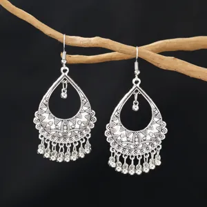 Vintage bohemian alloy drop earrings, intricate hollow carved tassel design, elegant detail view.