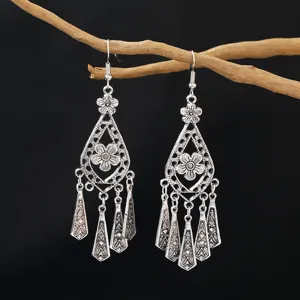 Detailed shot of retro silver bohemian hollow tear-drop alloy tassel earrings hanging.
