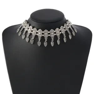 Detailed view of a vintage silver-colored metal carved choker necklace with bohemian pendants.