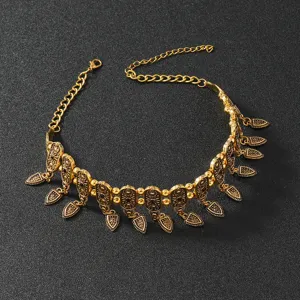 Vintage gold metal choker necklace featuring carved shield charms and retro boho aesthetic detail.