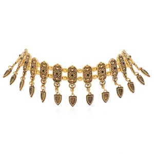 Vintage gold-tone metal choker necklace with intricate engraved patterns and dangling charms.